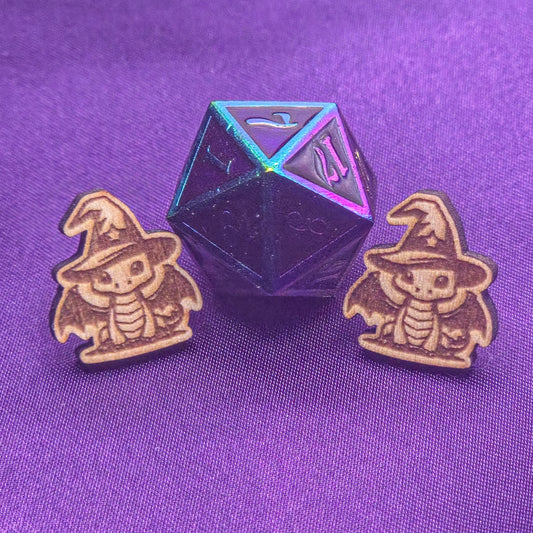 set of laser engraved earrings featuring dragons wearing wizard hats in front of a d20